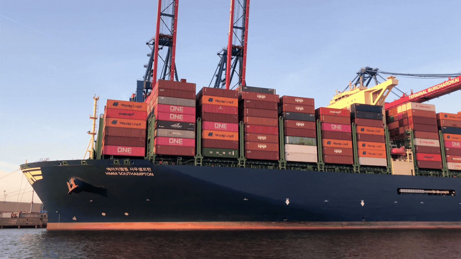 Container ship moored at a port with cranes above it